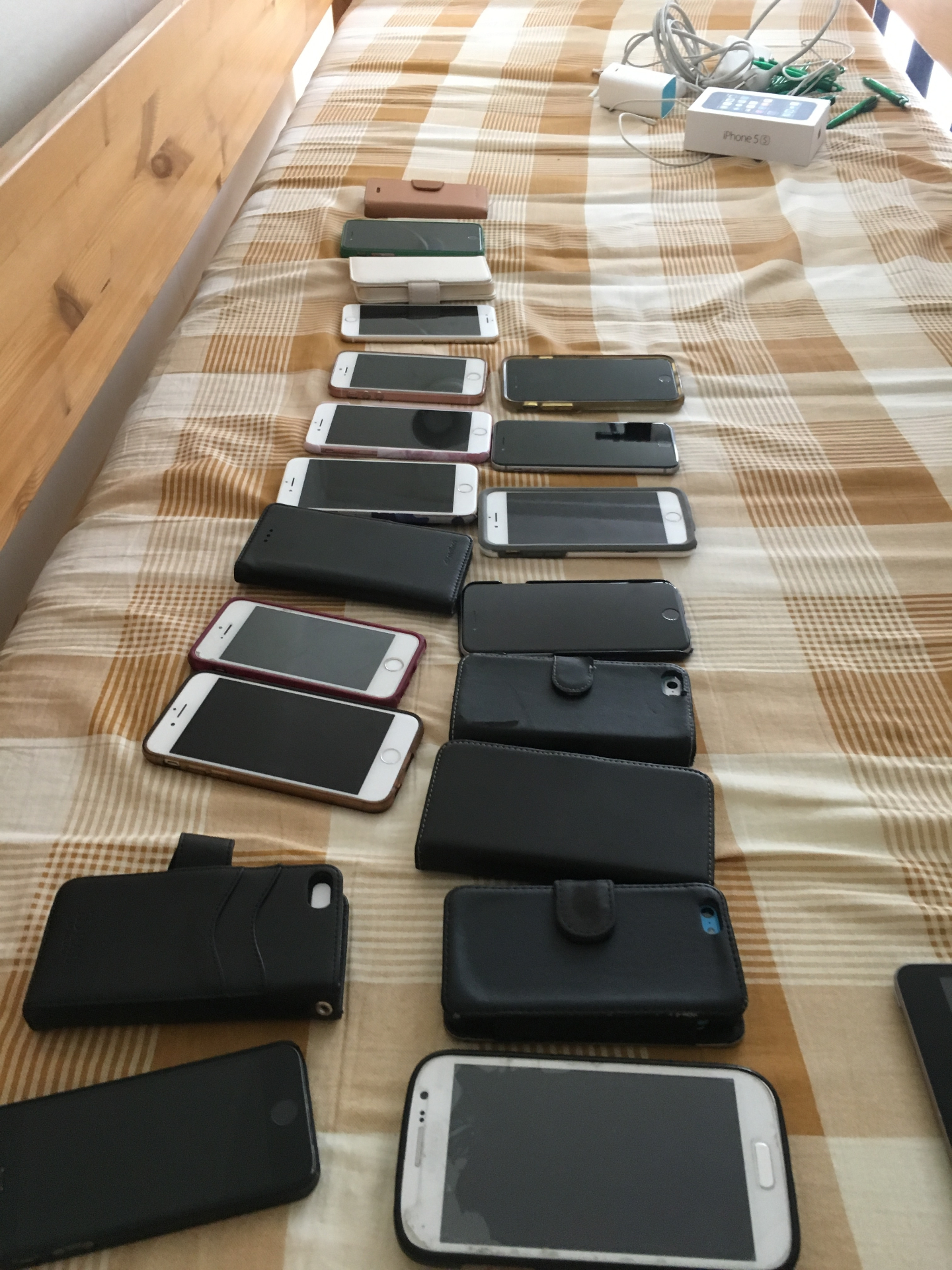 Flera olika mobiler och telefonfodral i rad, en bild av splittrad systemflora